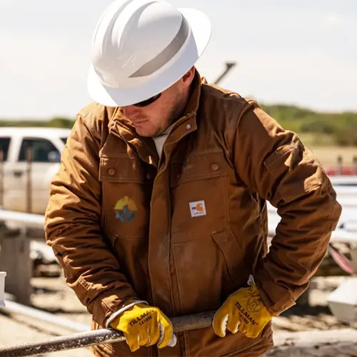 Construction worker in custom branded jacket and hard hat on a Miami jobsite