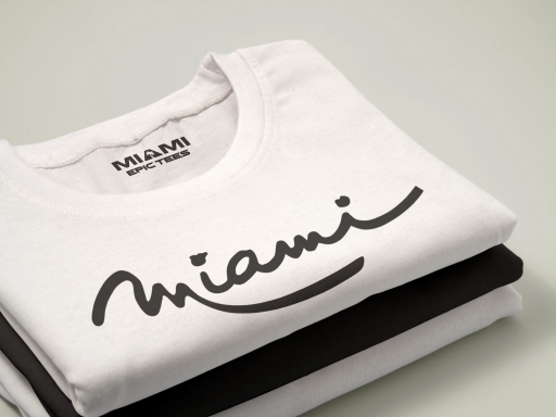 Folded white t-shirt with “Miami” script and Miami Epic Tees neck label