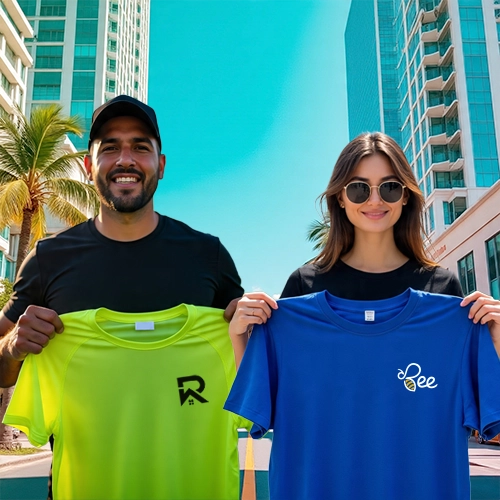 Man and woman holding custom printed t-shirts with logos, standing in downtown Miami with palm trees and high-rise buildings.