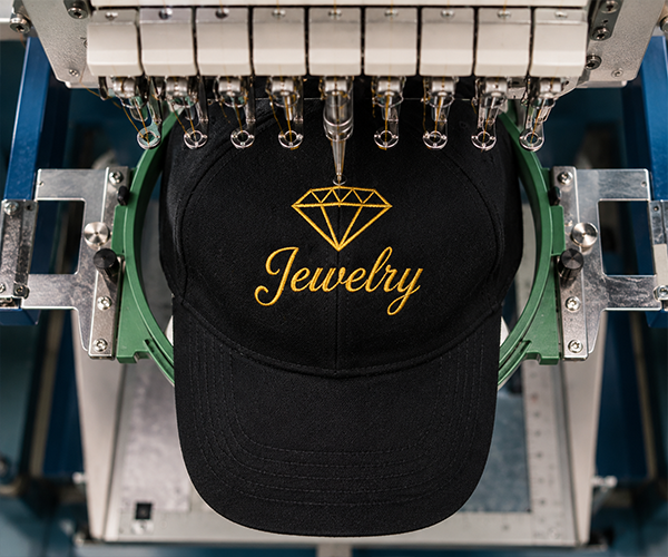 Embroidery machine stitching a custom logo onto a black baseball cap for professional embroidered hat production in Miami.