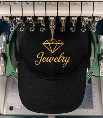 Embroidery machine stitching a custom logo onto a black baseball cap for professional embroidered hat production in Miami.